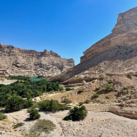 Turquoise wadi pool framed by rock canyon walls