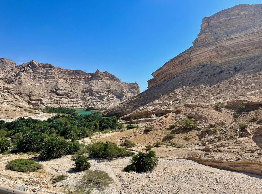 Turquoise wadi pool framed by rock canyon walls